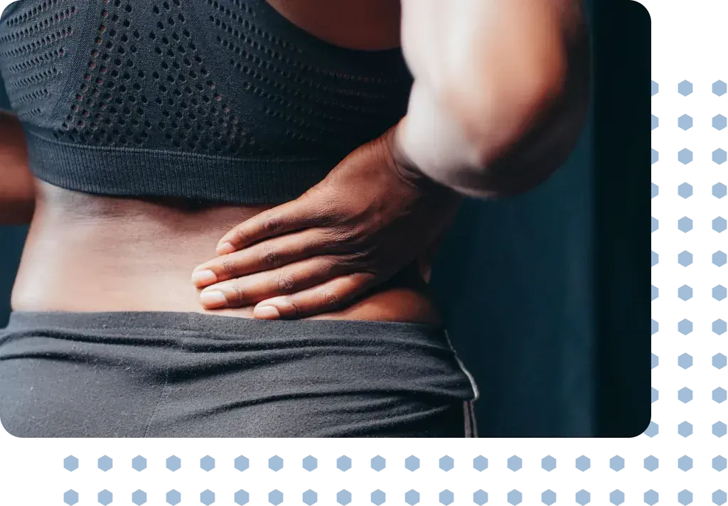 A woman in pain holding her lower back