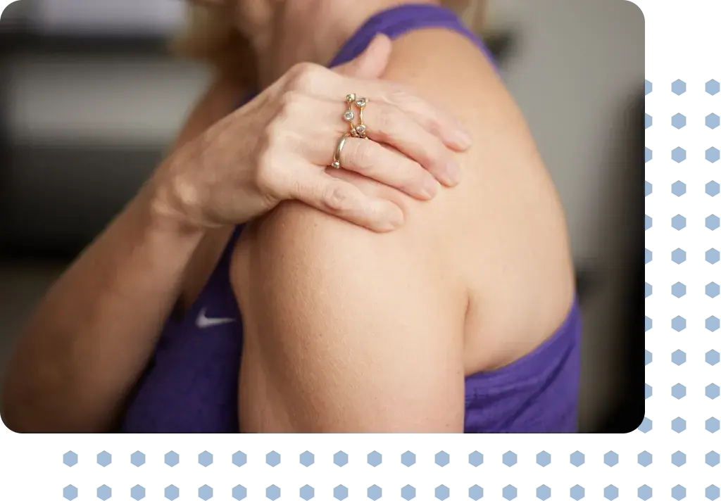 A woman in pain holding her shoulder