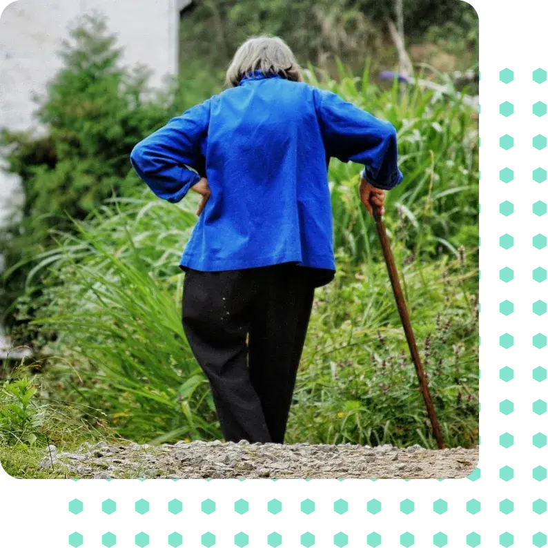A woman walking with a walking stick after a failed back operation.