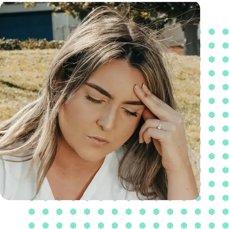A woman with a headache holding her forehead.