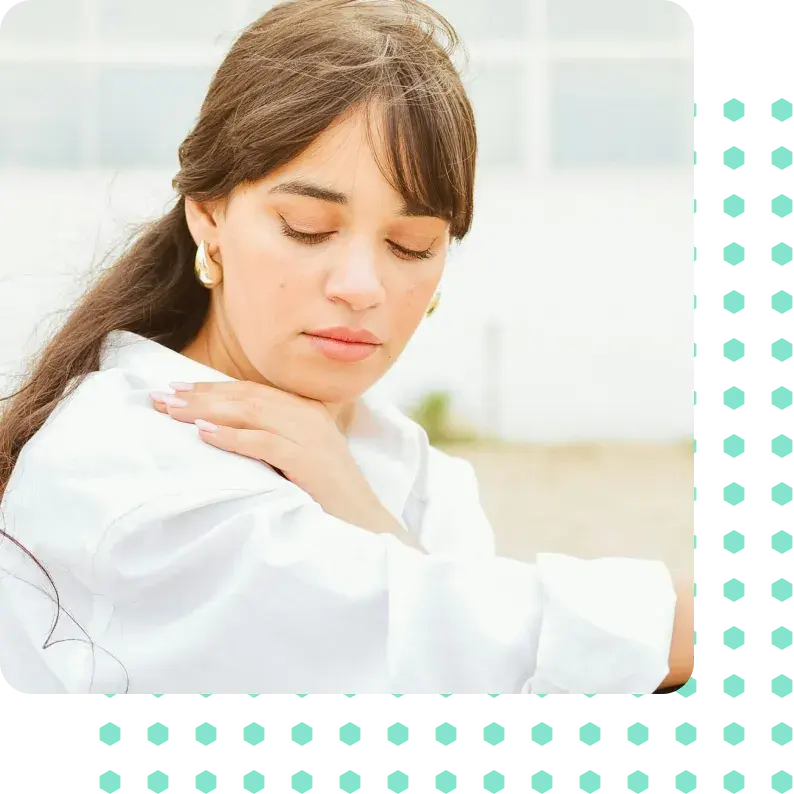 A woman in pain holder her shoulder.