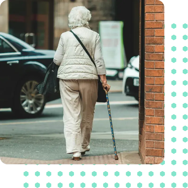 A woman walking with a walking stick.